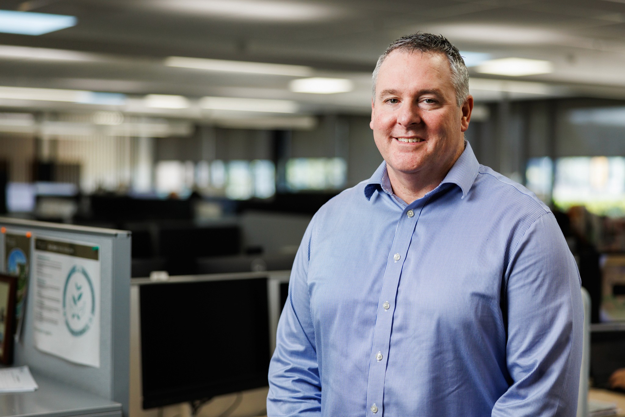 A man smiles in front of  an office