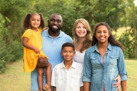 family standing on deck in front of roof built by louisville roofing contractor Andes