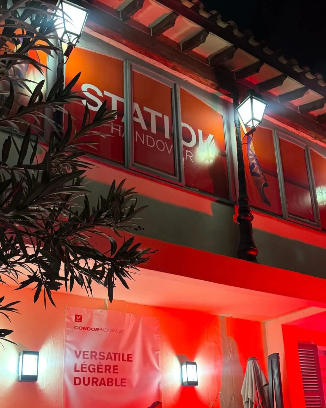 Photographie d'architecture commerciale et façade de nuit éclairée en rouge pour l'événement.