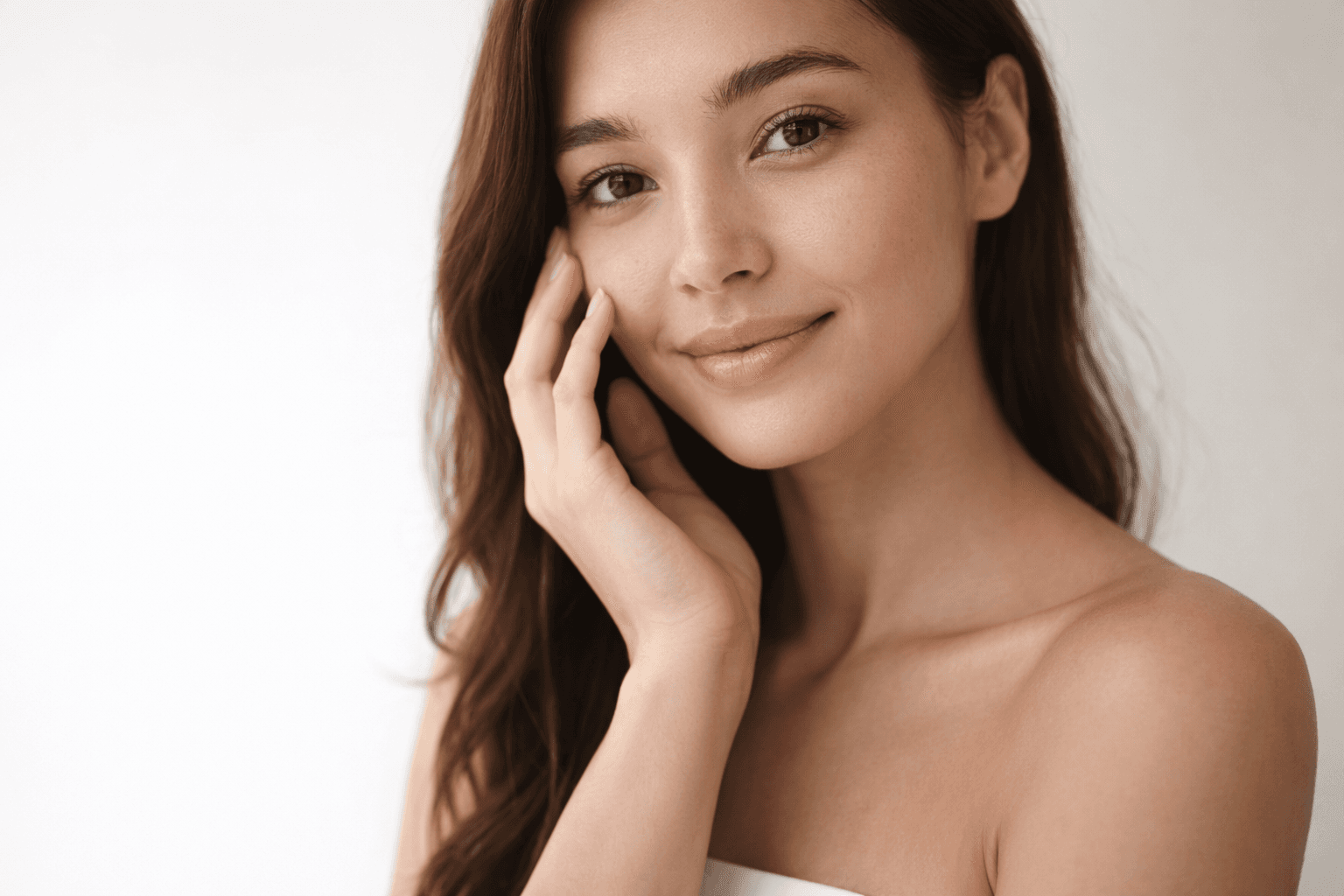 Close-up of a woman's hands adorned with rings and layered necklaces, highlighting her smooth skin and elegant jewelry