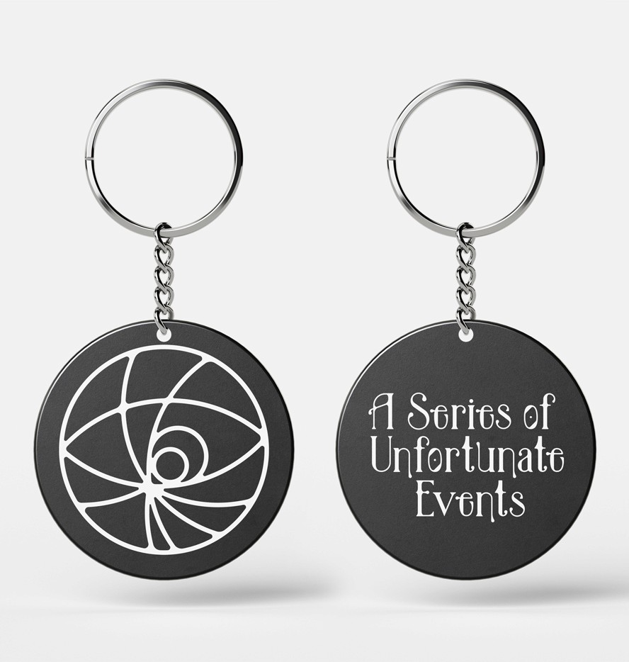 A mockup of the movie merchandise keychain. A black round plastic keychain with white writing for the movie logo.