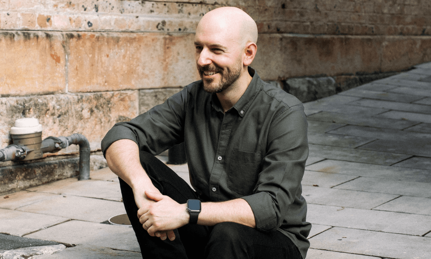 Black and white image of people working at a table with laptops, showing hands gesturing during discussion of digital content displayed on screens, with fabrica® logo in the corner.