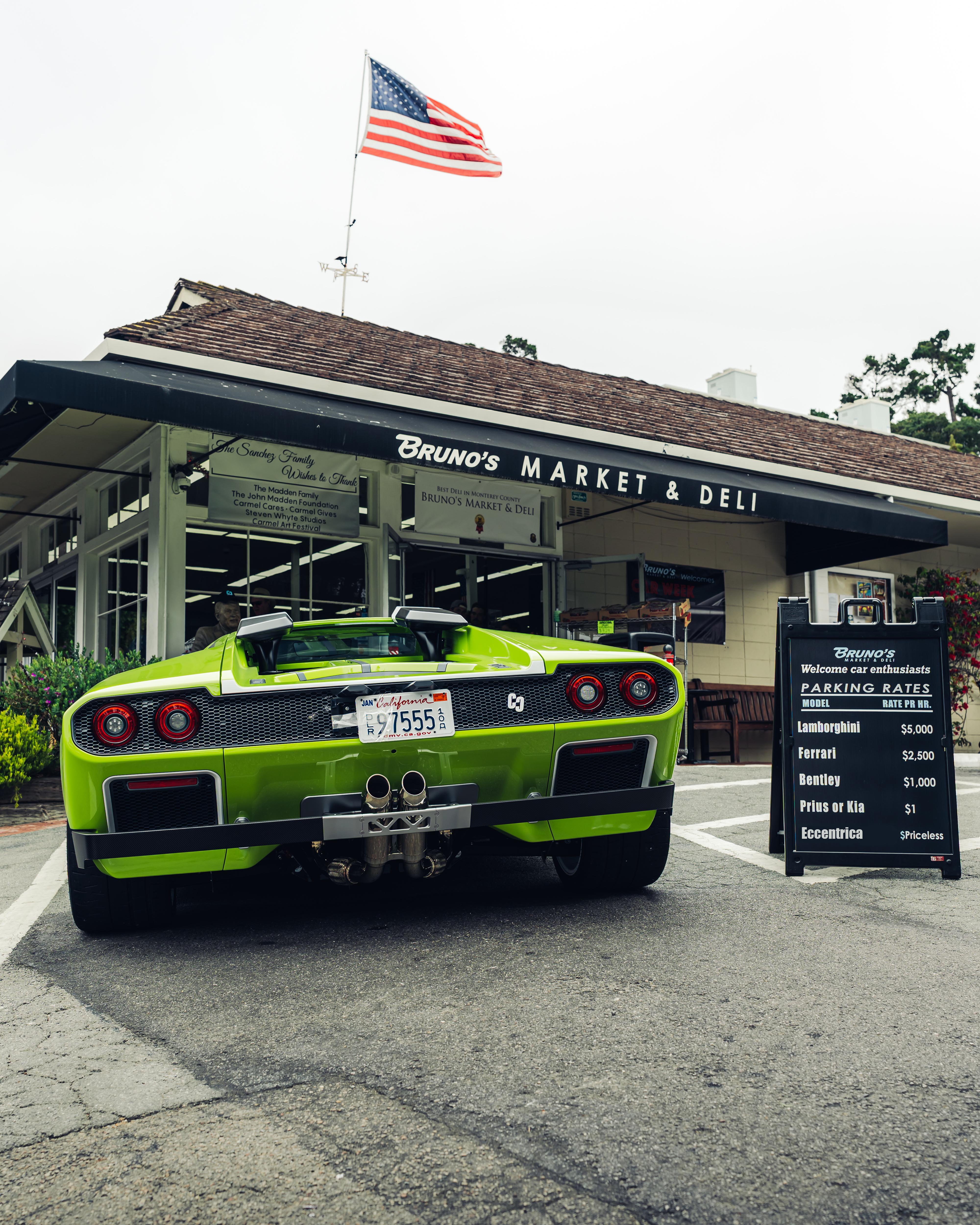 Foto posteriore di eccentrica verde parcheggiata davanti a casa con bandiera americana