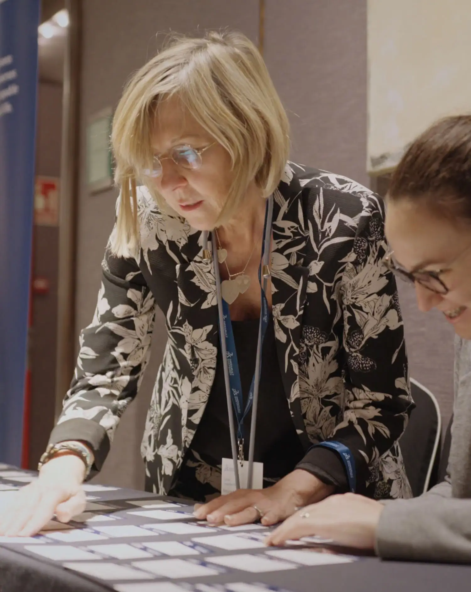 Portfolio Thankium: Mujer revisando etiquetas en conferencia profesional.