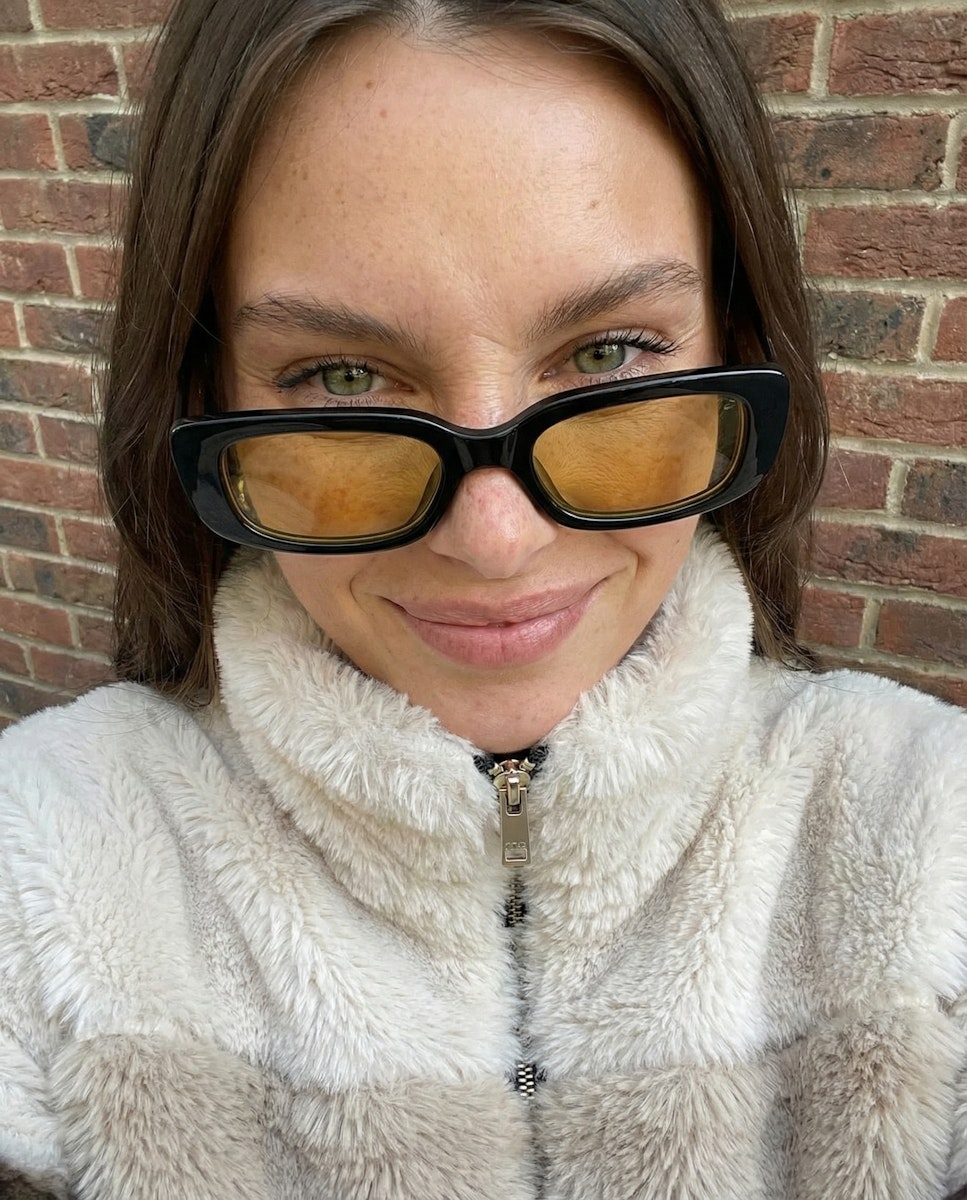 A woman puttong on tinted glasses