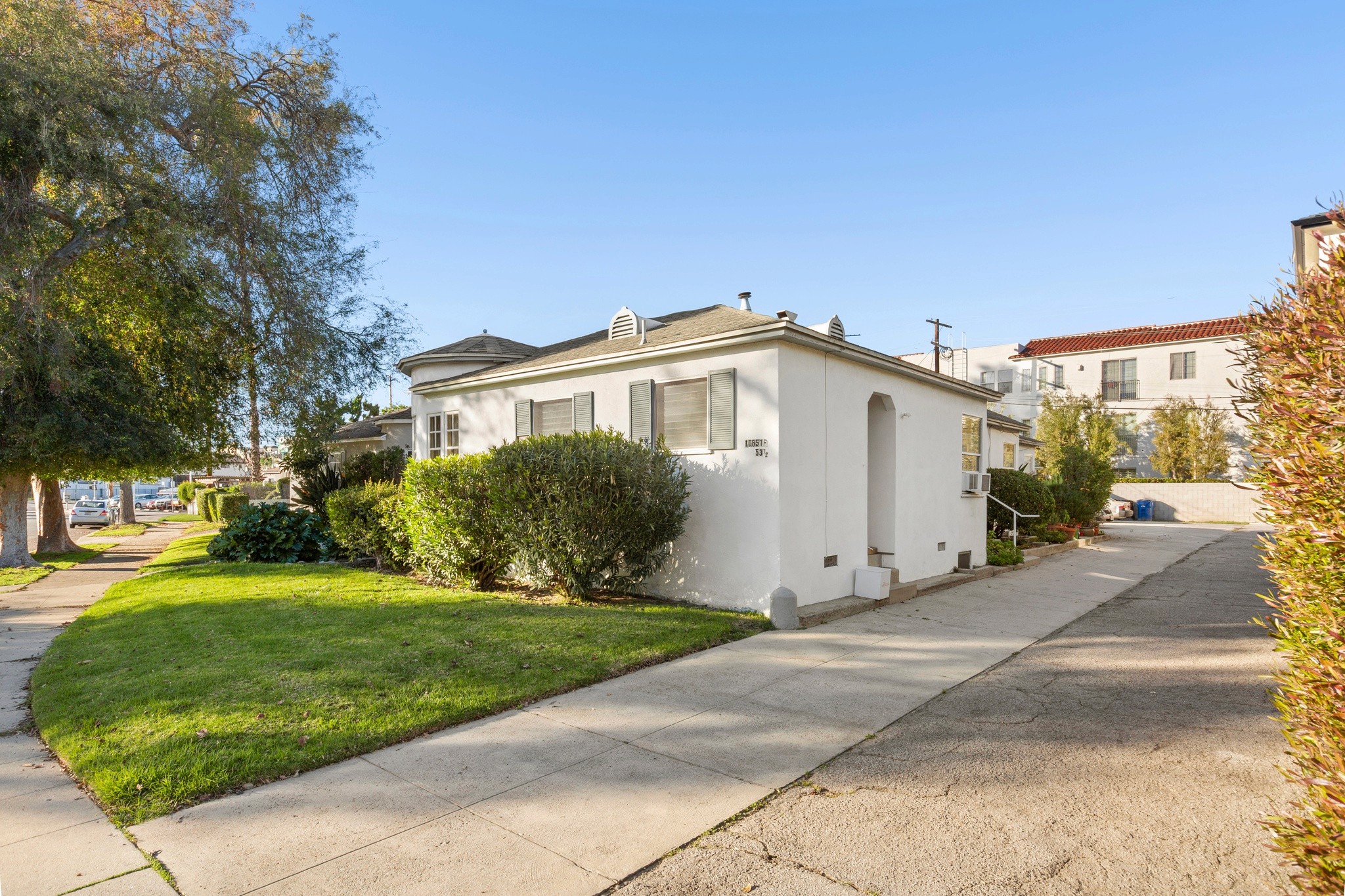 Side elevation showing classic architecture and private entrances at the Toluca Lake triplex located at 10651 Whipple.