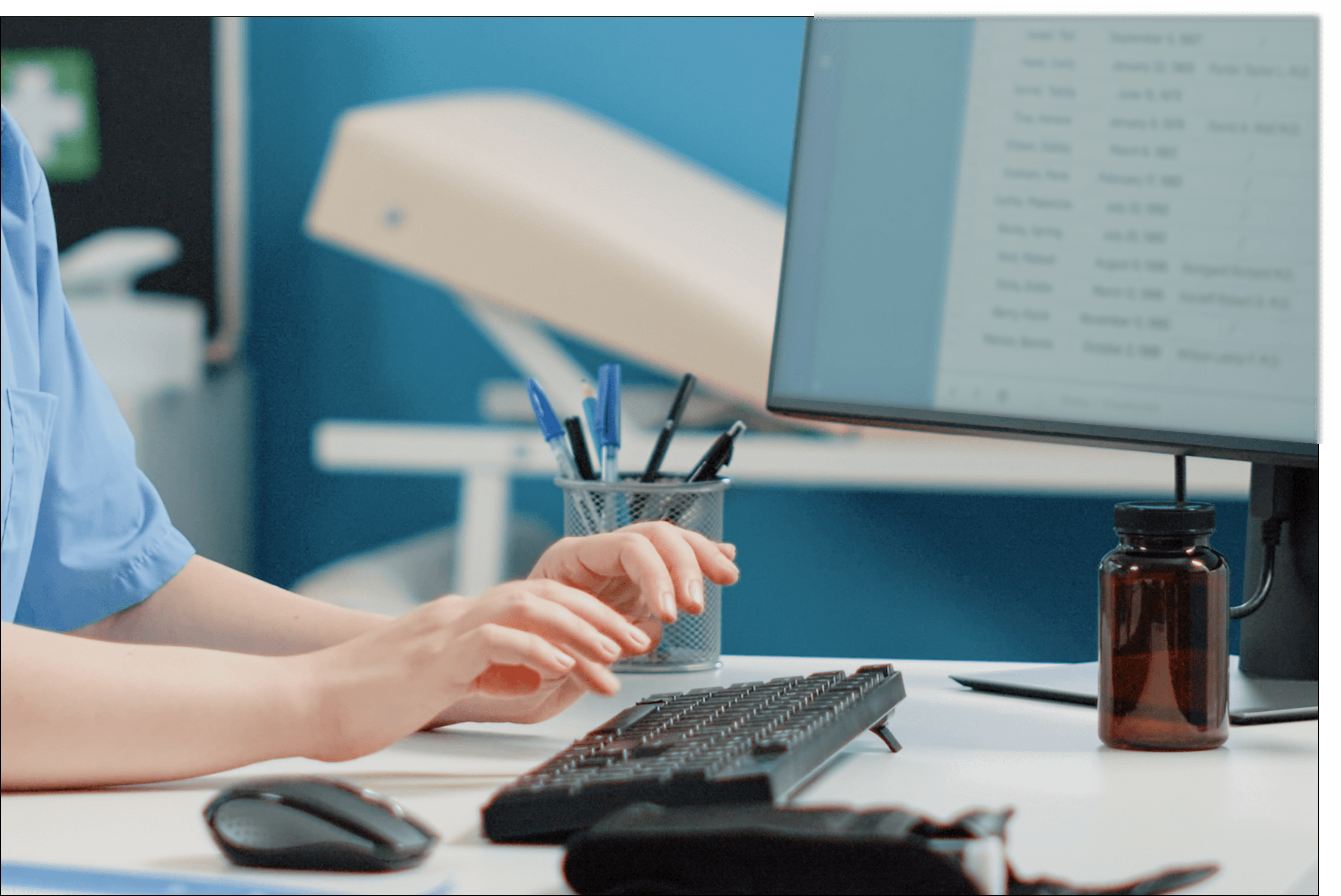 A healthcare professional entering data into a computer system, representing the documentation and record-keeping required for ISO 13485 certification compliance.
