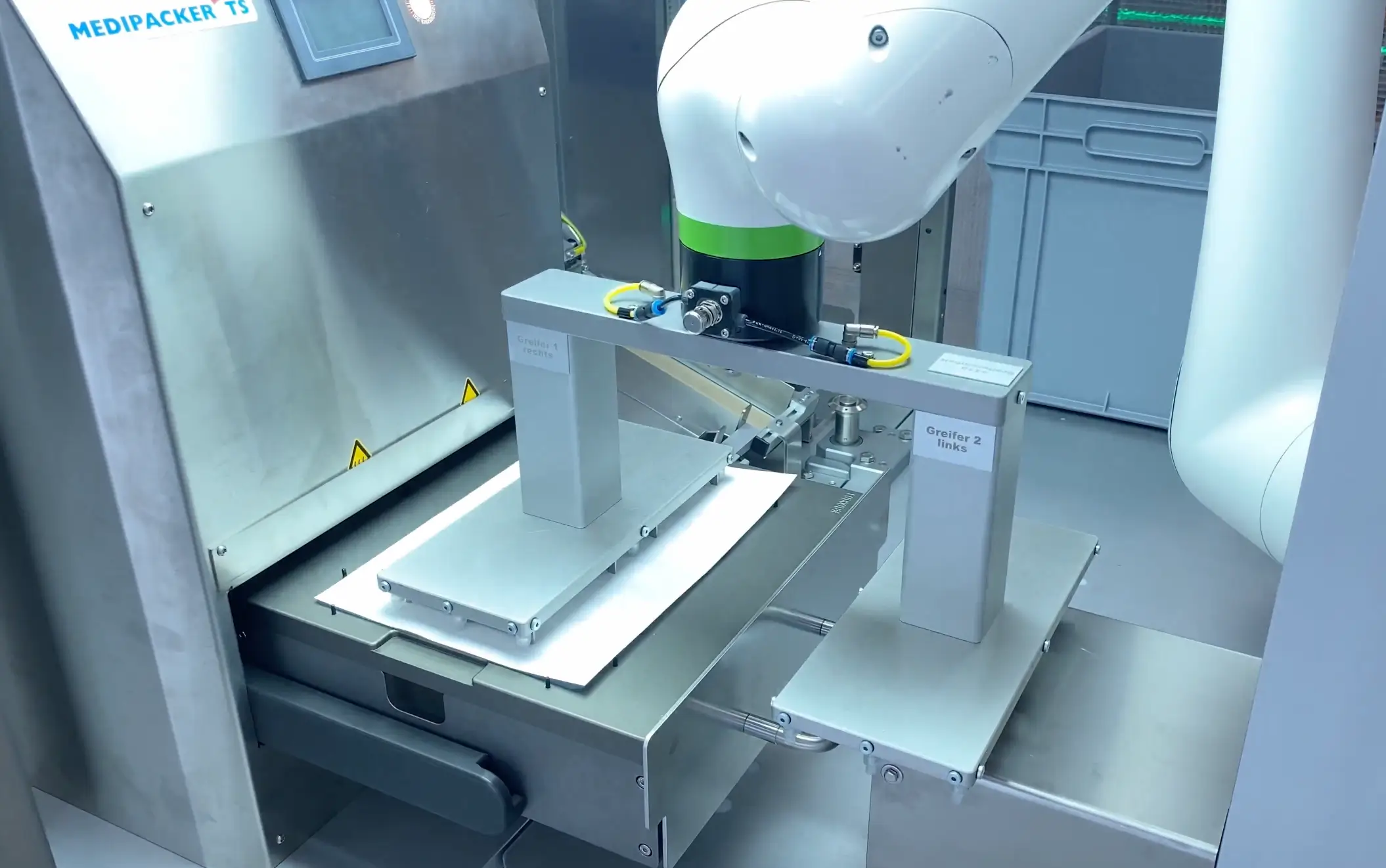 Robot with a 2-arm gripper is feeding tyvek