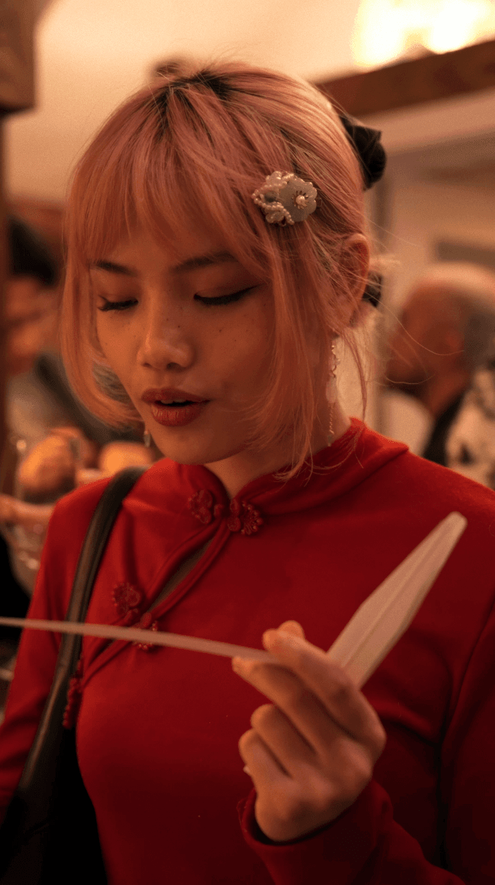 Bride sitting on ground against wall, groom standing nearby