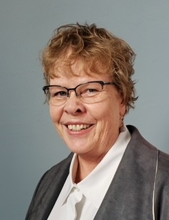 woman in black crew neck t-shirt wearing brown framed eyeglasses standing on rocky shore during
