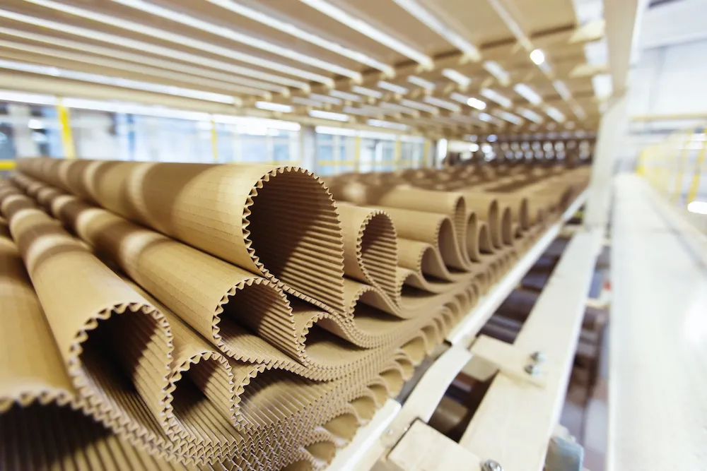Corrugated packaging sheets in automated production line at modern corrugated manufacturing facility, showcasing sustainable packaging, intelligent manufacturing, and advanced corrugated packaging technology.