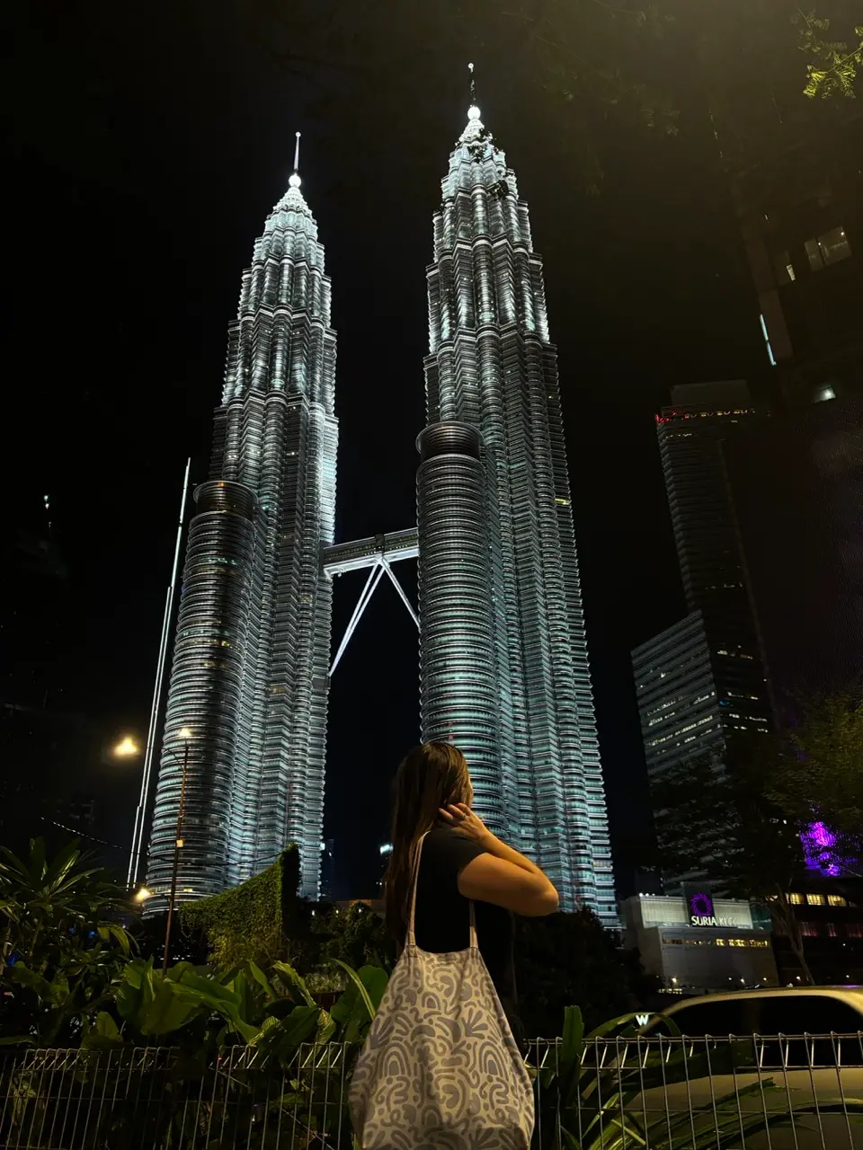 petronas torens in de avond met een vrouw op de voorgrond