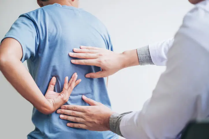 Person holding their lower back in pain