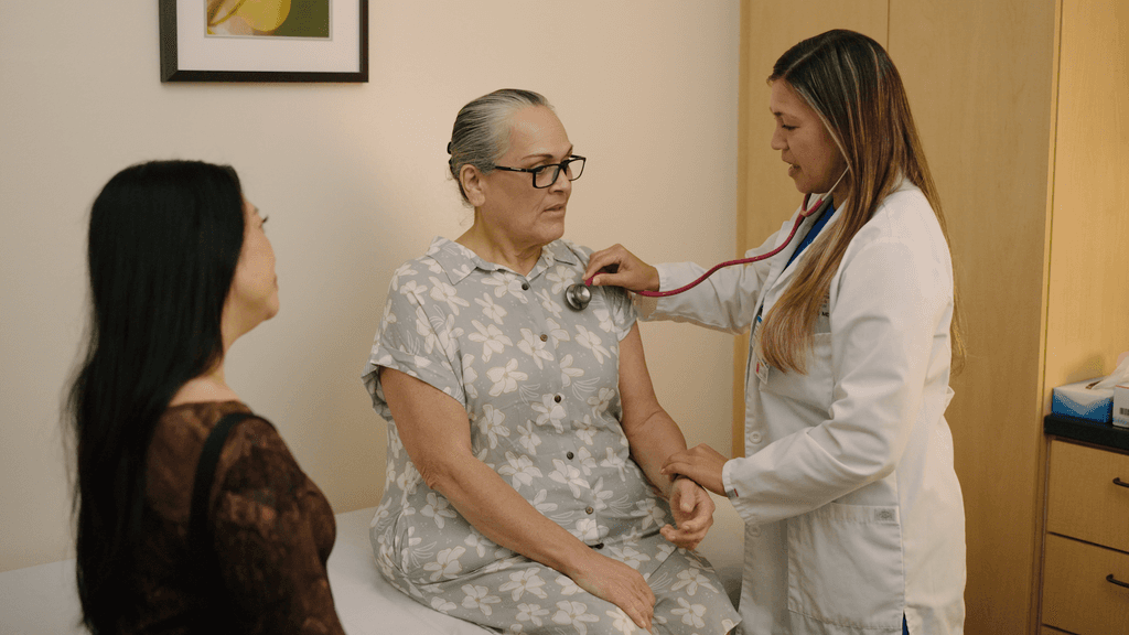 Doctor examining patient with another family member present