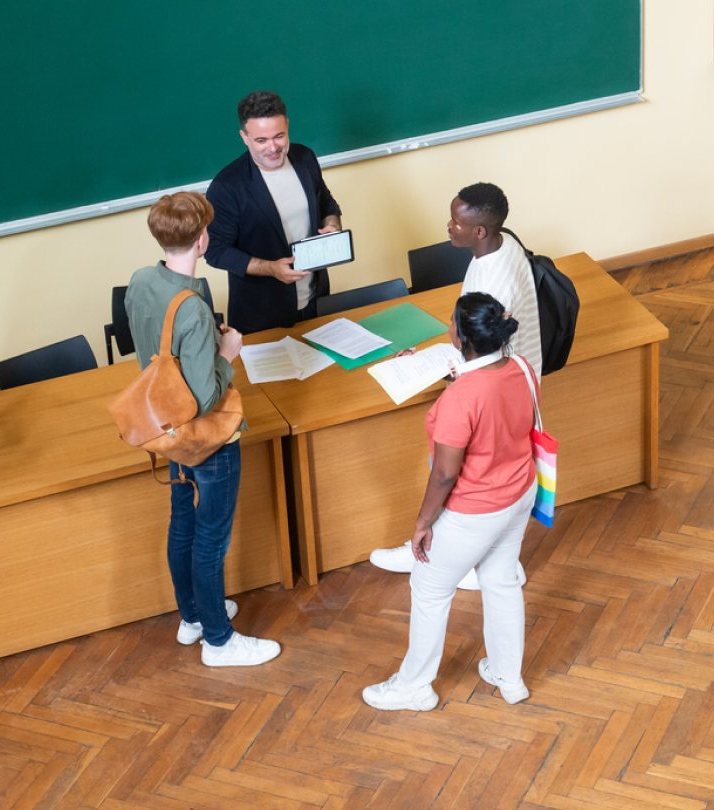 An instructor and three students talking around a desk