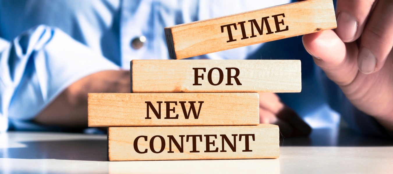 Wooden blocks spelling Time For New Content