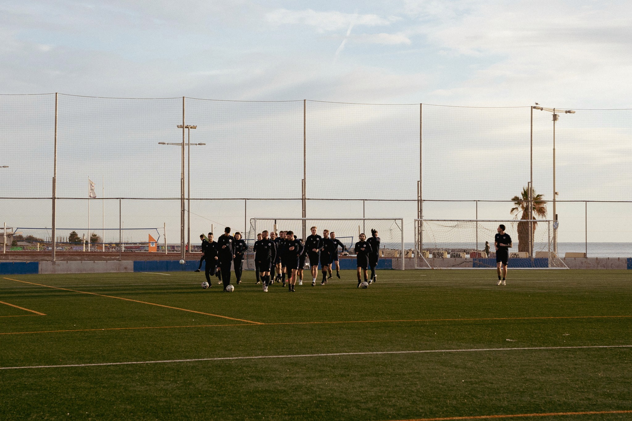 Voetbalteam in actie op Camp Municipal de Futbol Poblenou - Agapito Fernández, tijdens een intensieve trainingssessie.
