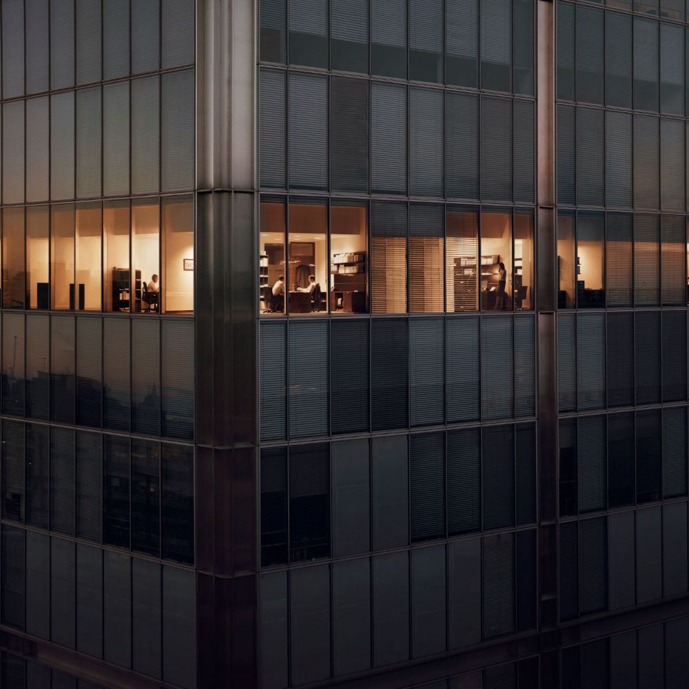 Serious woman centered among blurry hands holding up mobile phones.