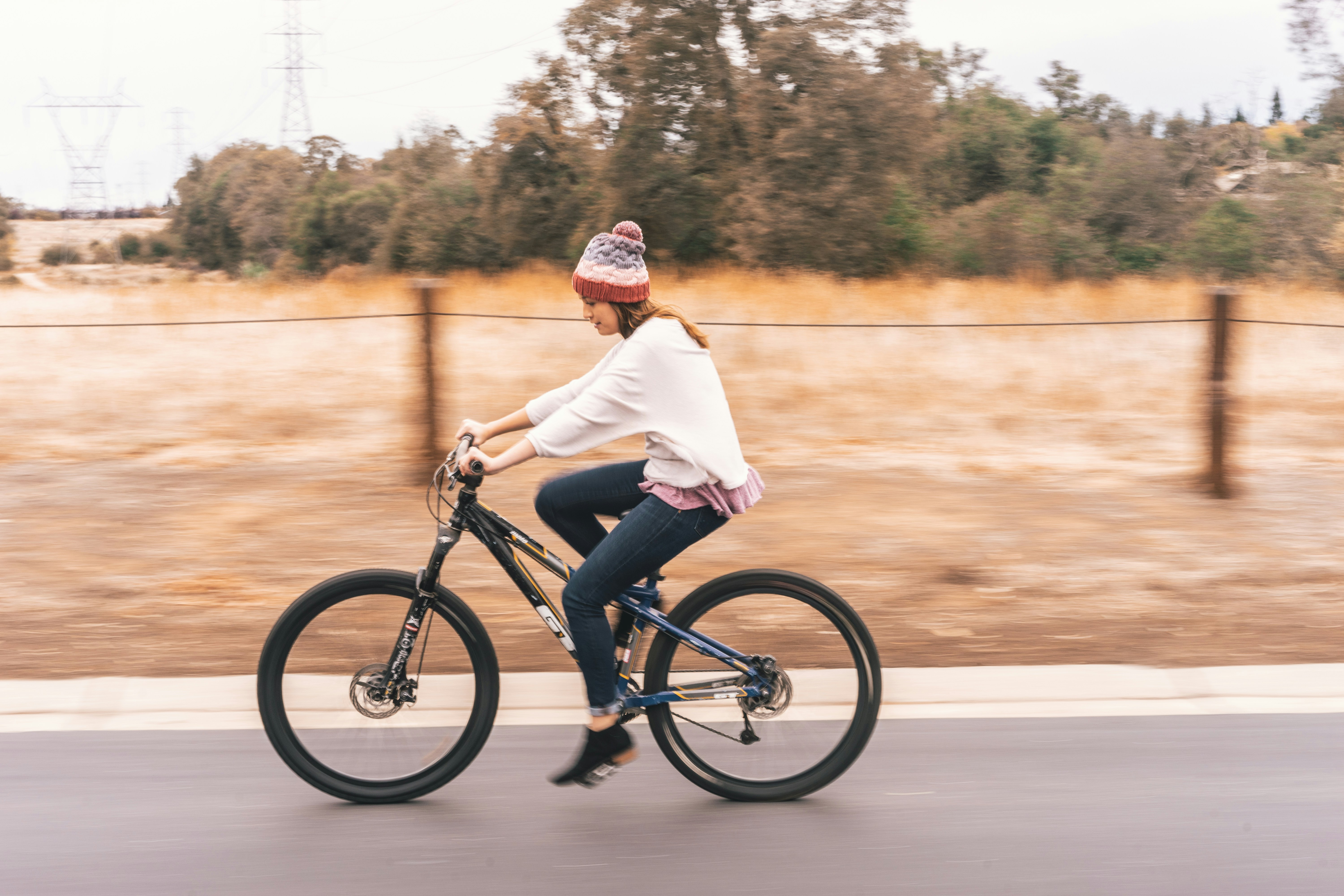 woman riding bicycle near tree during daytime