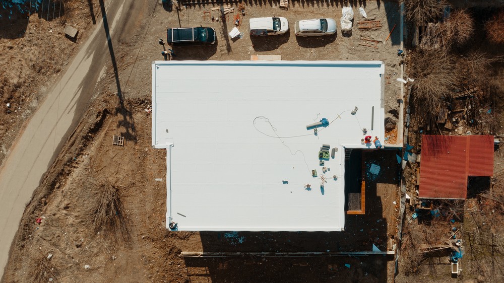 Aerial view of an apartment building with flat roof in construction, ballasted system with geotextile, PVC or EPDM membrane