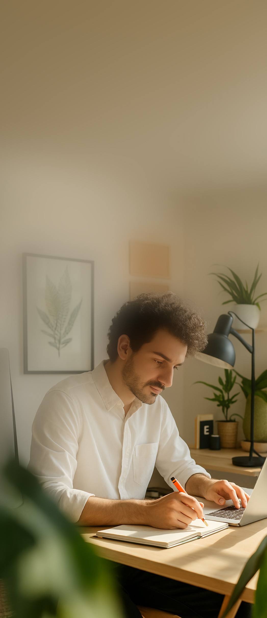 Man sitting at desk on computer taking notes