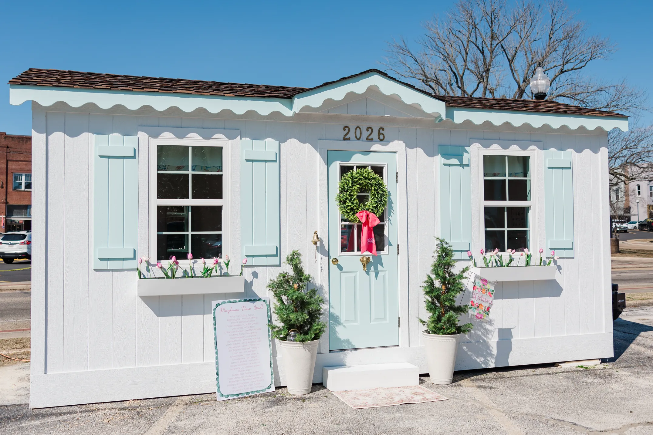 Luxury table setting by Sarah Overall Events with pink embroidered napkins, gold-rimmed plates, floral arrangements, and personalized menus in Shreveport.