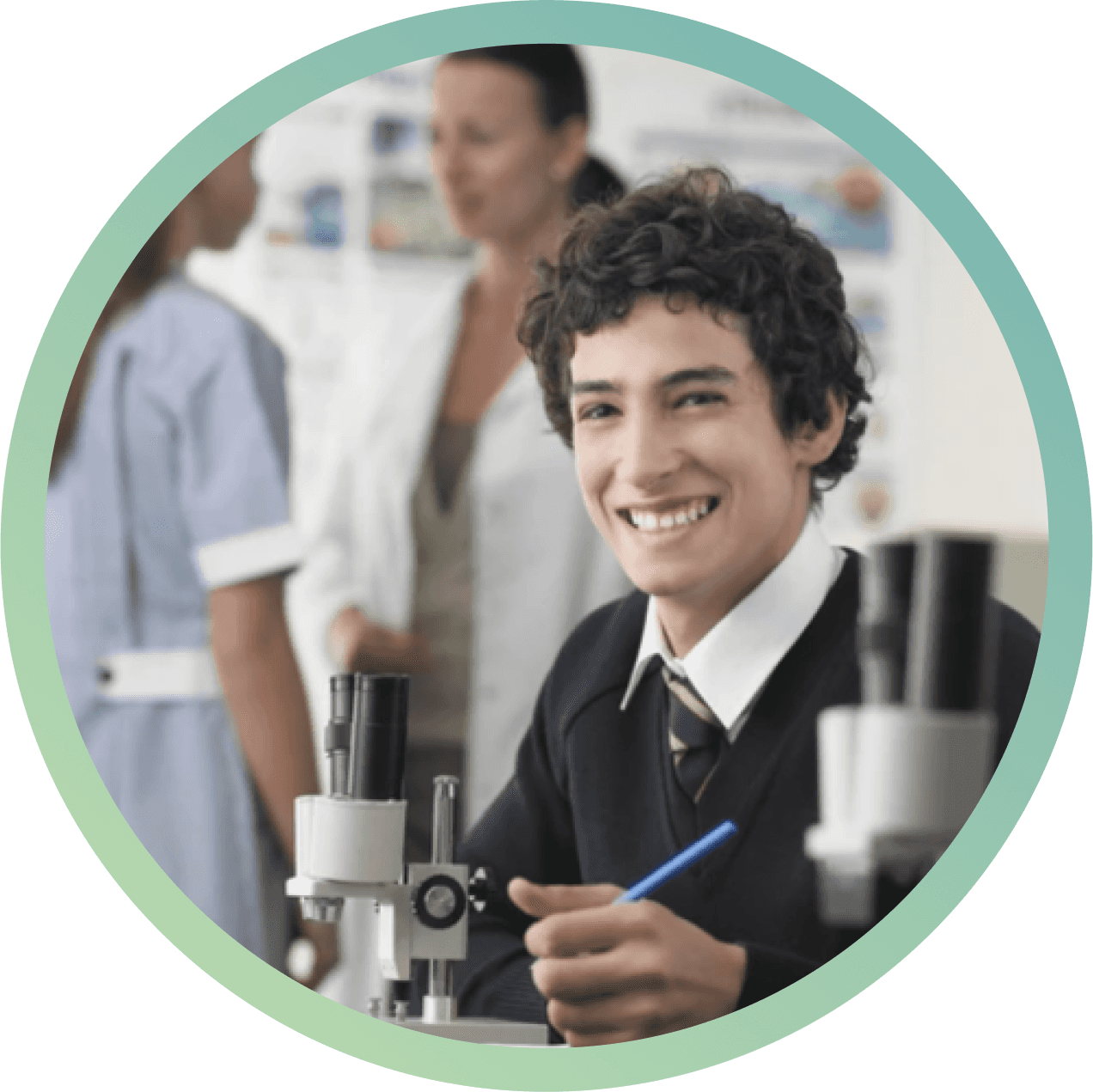 High school boy smiling while studying science under a microscope