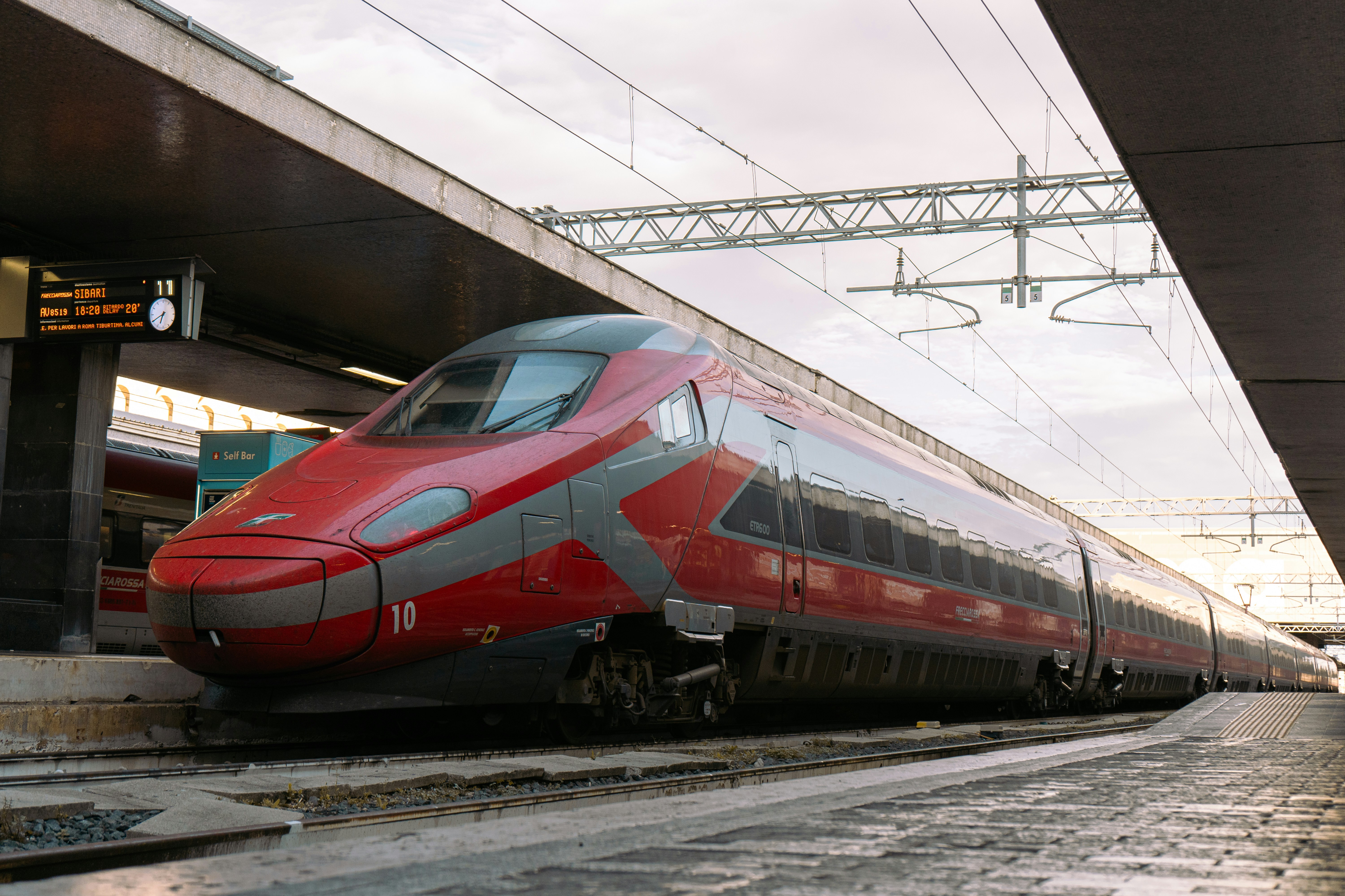 A sleek red high-speed train at a station.