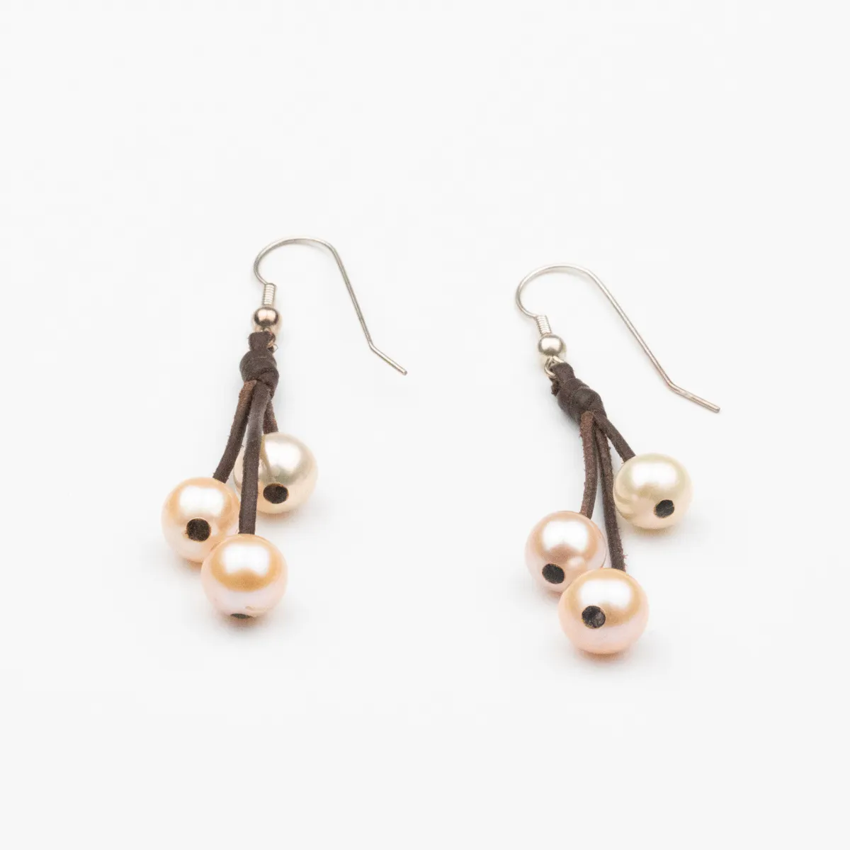 South Sea Pearl leather drop earrings with six round pearls in champagne and apricot tones on brown leather cords with silver ear wires — Manos de Oro Saint Barth