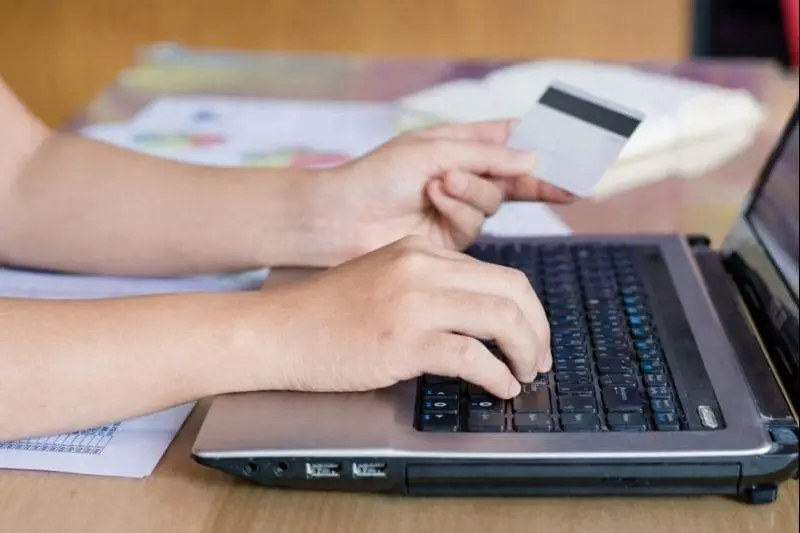 Man reviewing documents and credit history on laptop