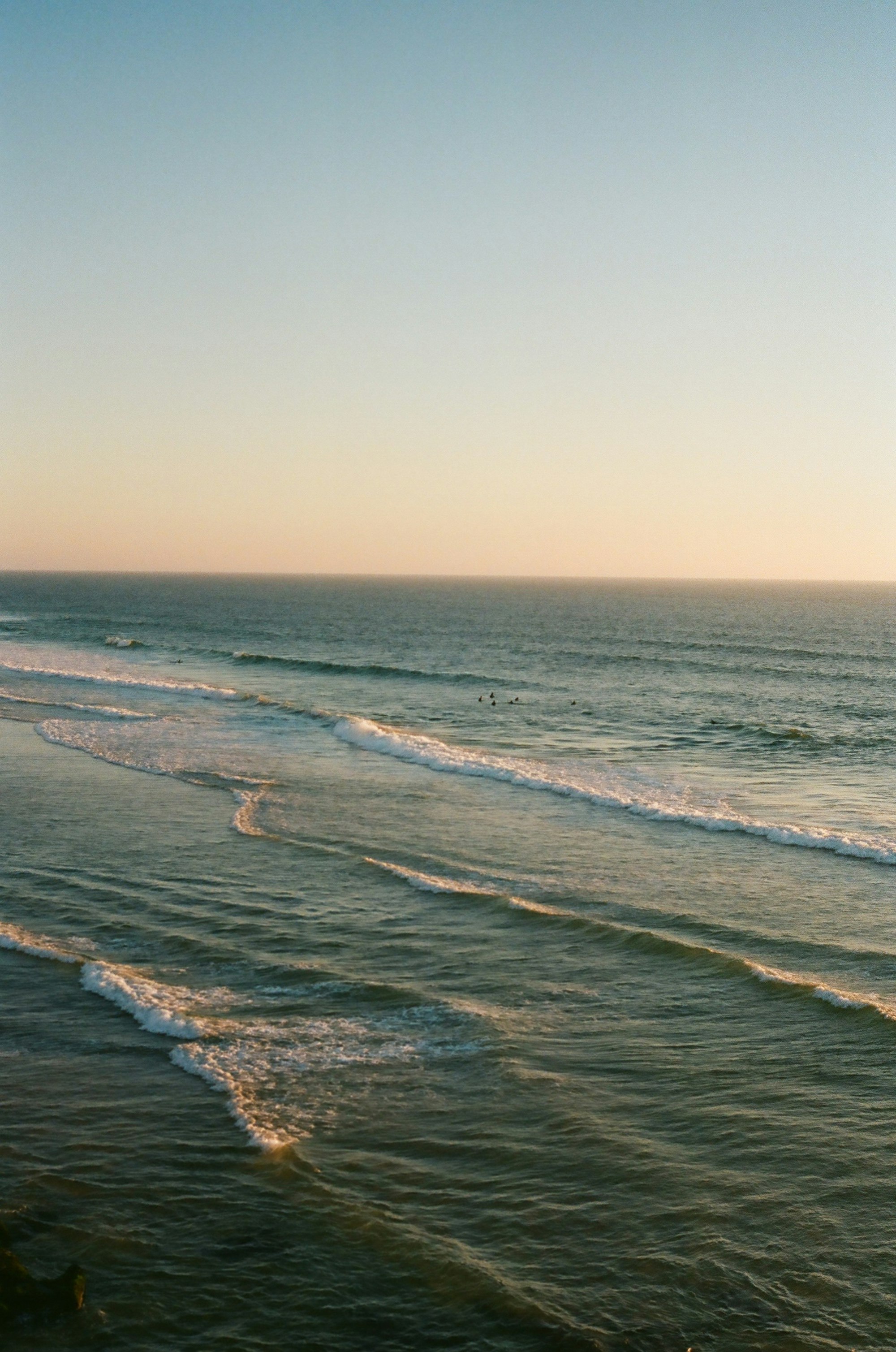 Waves rolling onto a sandy beach at sunset
