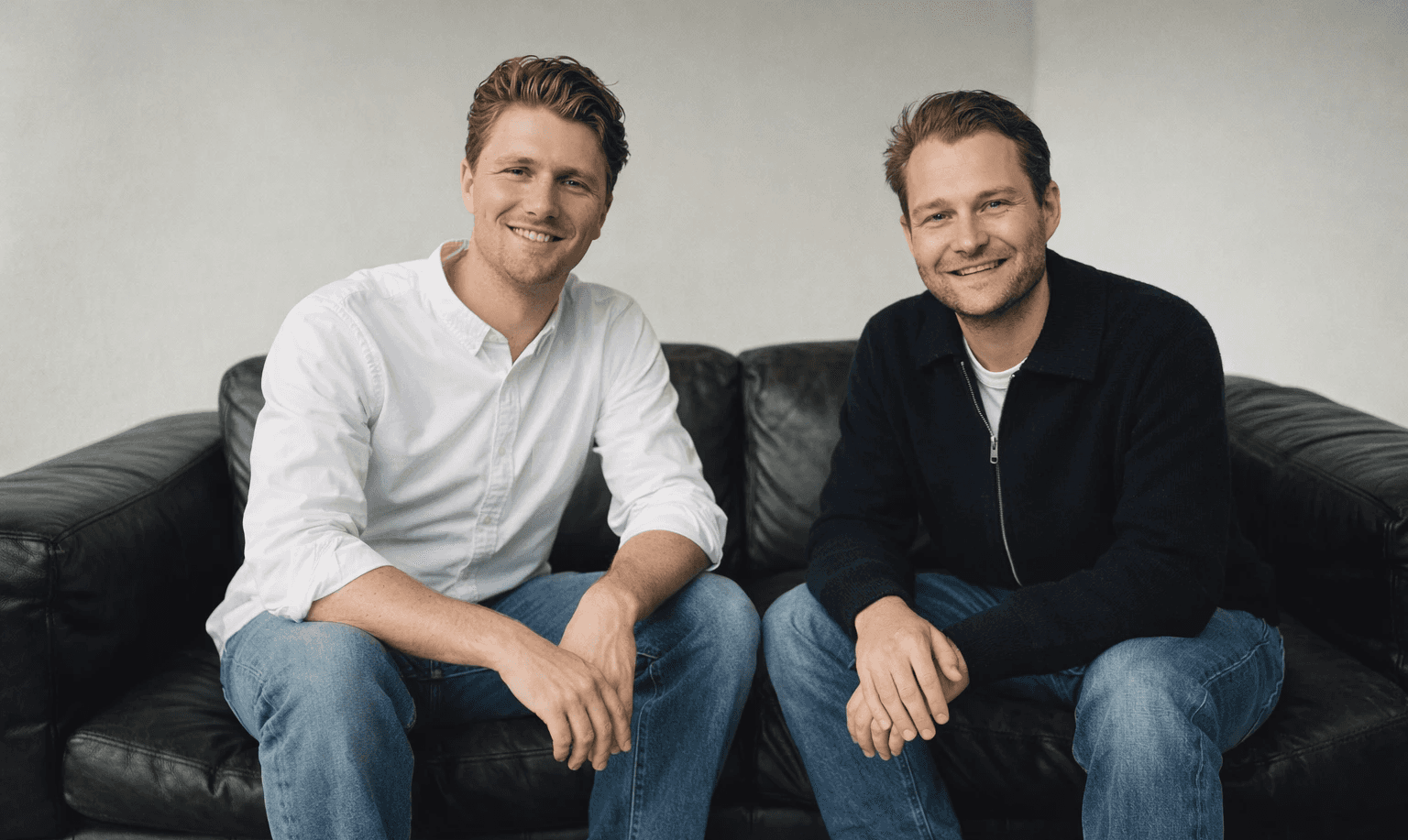 A group of four people engaged in a discussion while seated in a cozy, plant-filled setting.