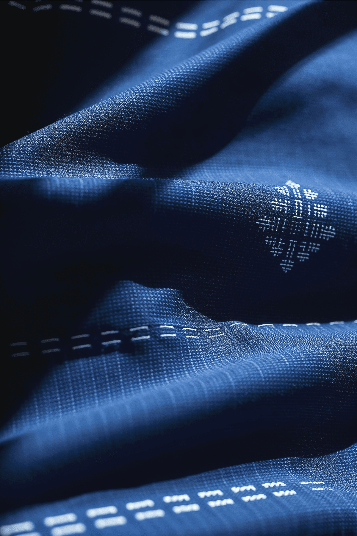 A closeup of a sashiko stitching on an indigo colored garment.