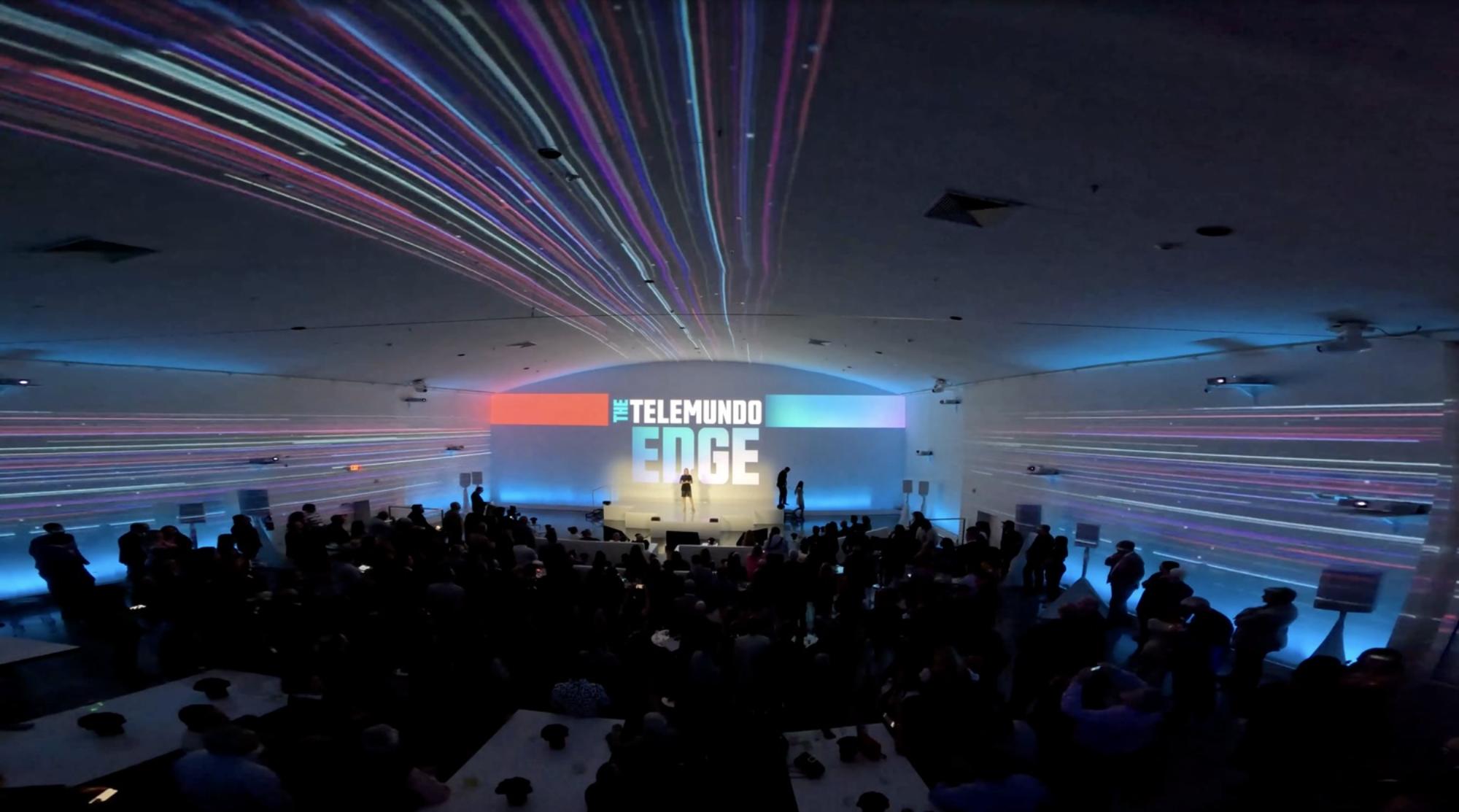 Projection-filled event room featuring Live Feel the Edge visual branding across the walls.