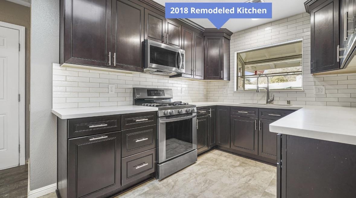 The original kitchen — dark espresso cabinets, white subway tile, stainless appliances