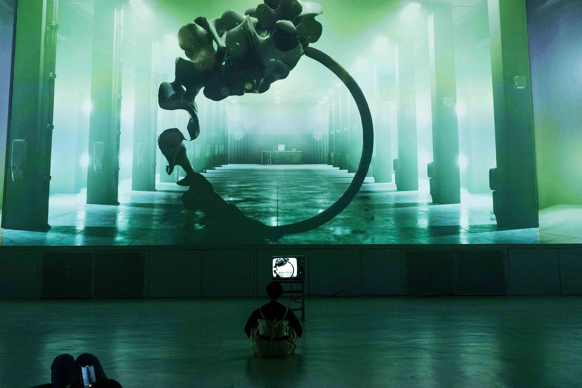 Digital art installation with abstract sculpture and screen.