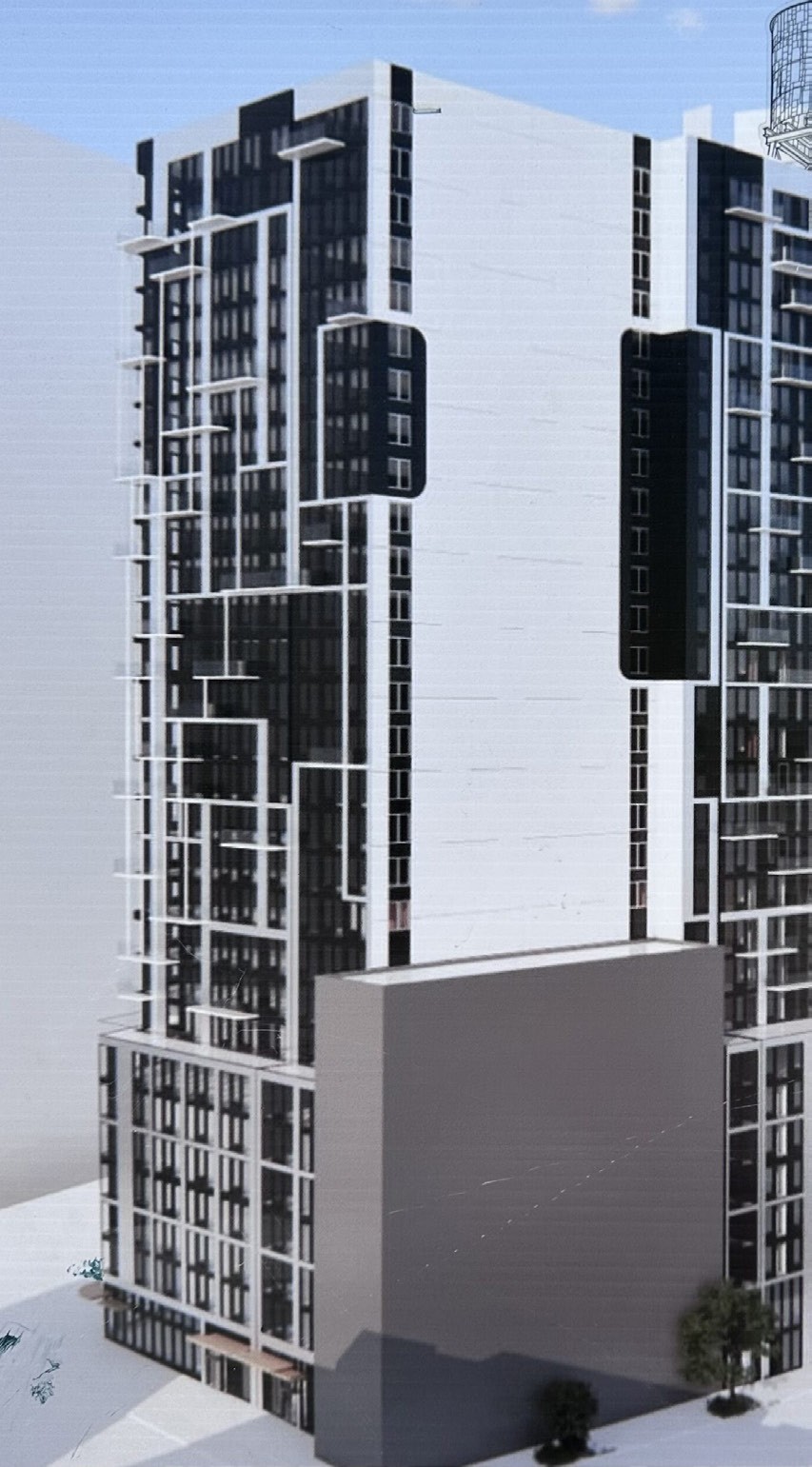 Tall modern skyscraper with vertical lines, viewed against a clear blue sky.