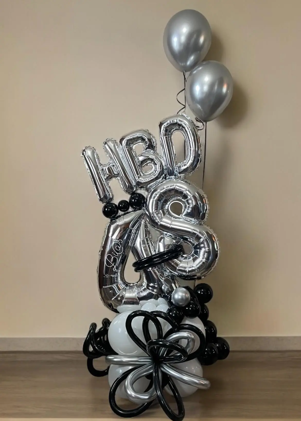 Balloon arrangement in black, silver, and white featuring a prominent “HBD” and the number “48,” accented with metallic balloons and a sophisticated color palette. Ideal for milestone celebrations. Susa’s Sweets & Balloons.