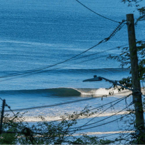 Surfers ride waves on a sunny day – surfboard rental in tamarindo.