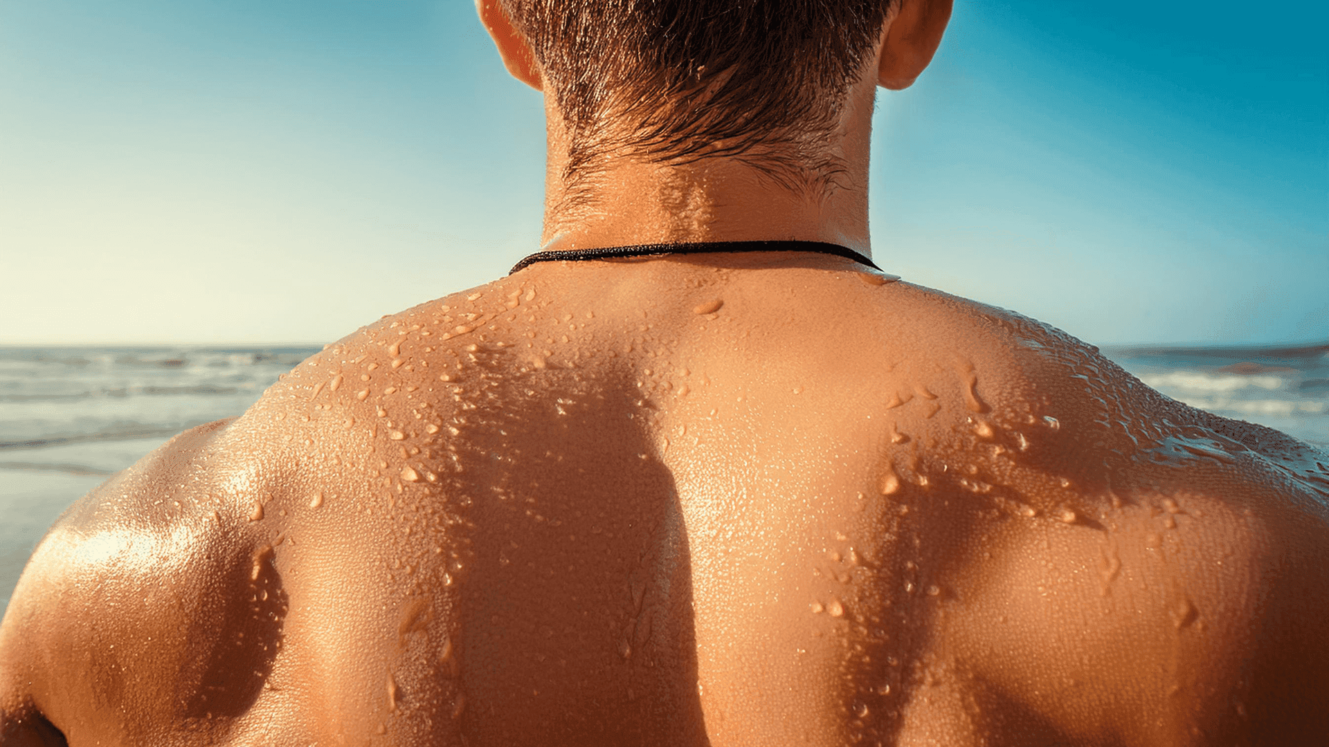 Close-up of a sunlit man’s wet shoulders at the beach, highlighting the relaxed, clothing-optional poolside vibe at Club Vieques.