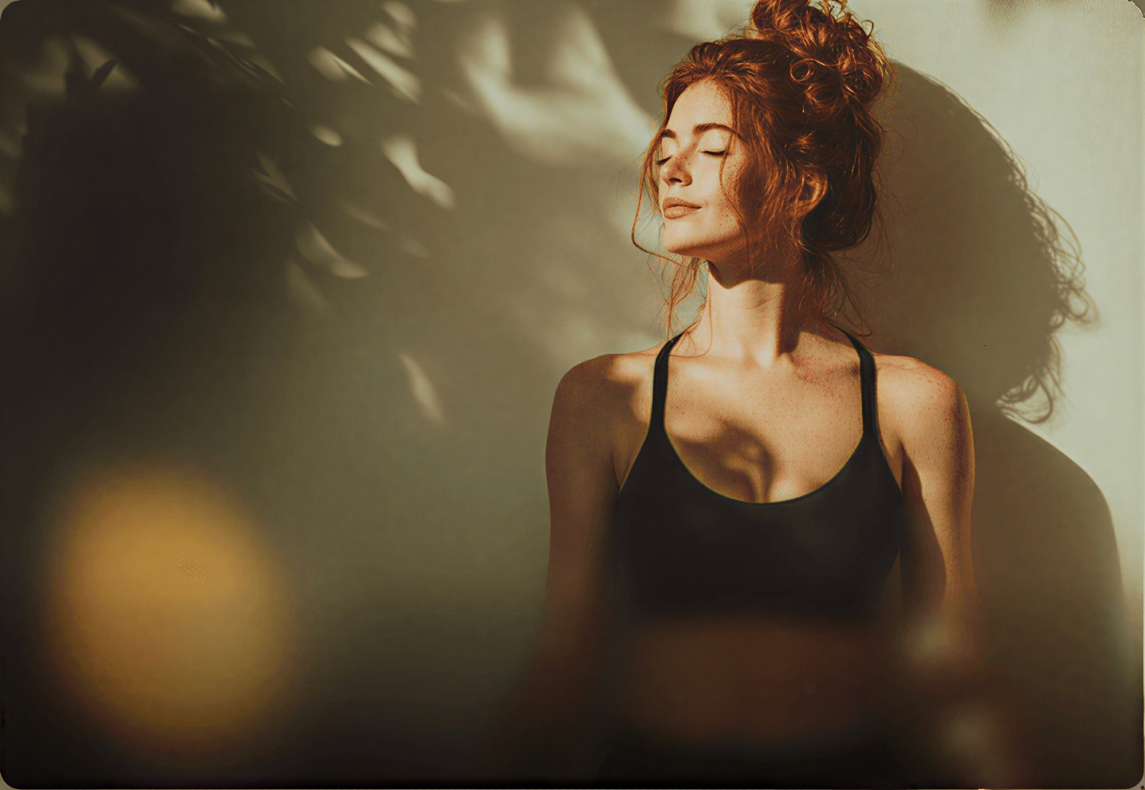 Woman sits in desert watching bright orange sunset over horizon.