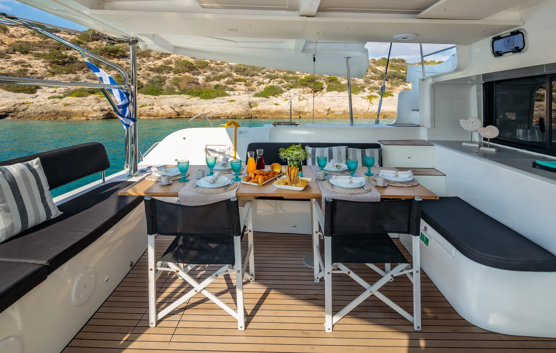 White Rock 36 speedboat with captain at helm cruising calm blue waters near Paros coastline with hills in background.