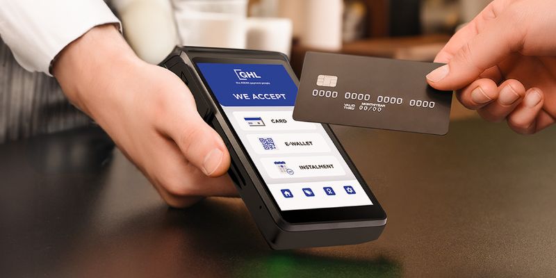 A customer tapping their credit card on the GHL terminal.