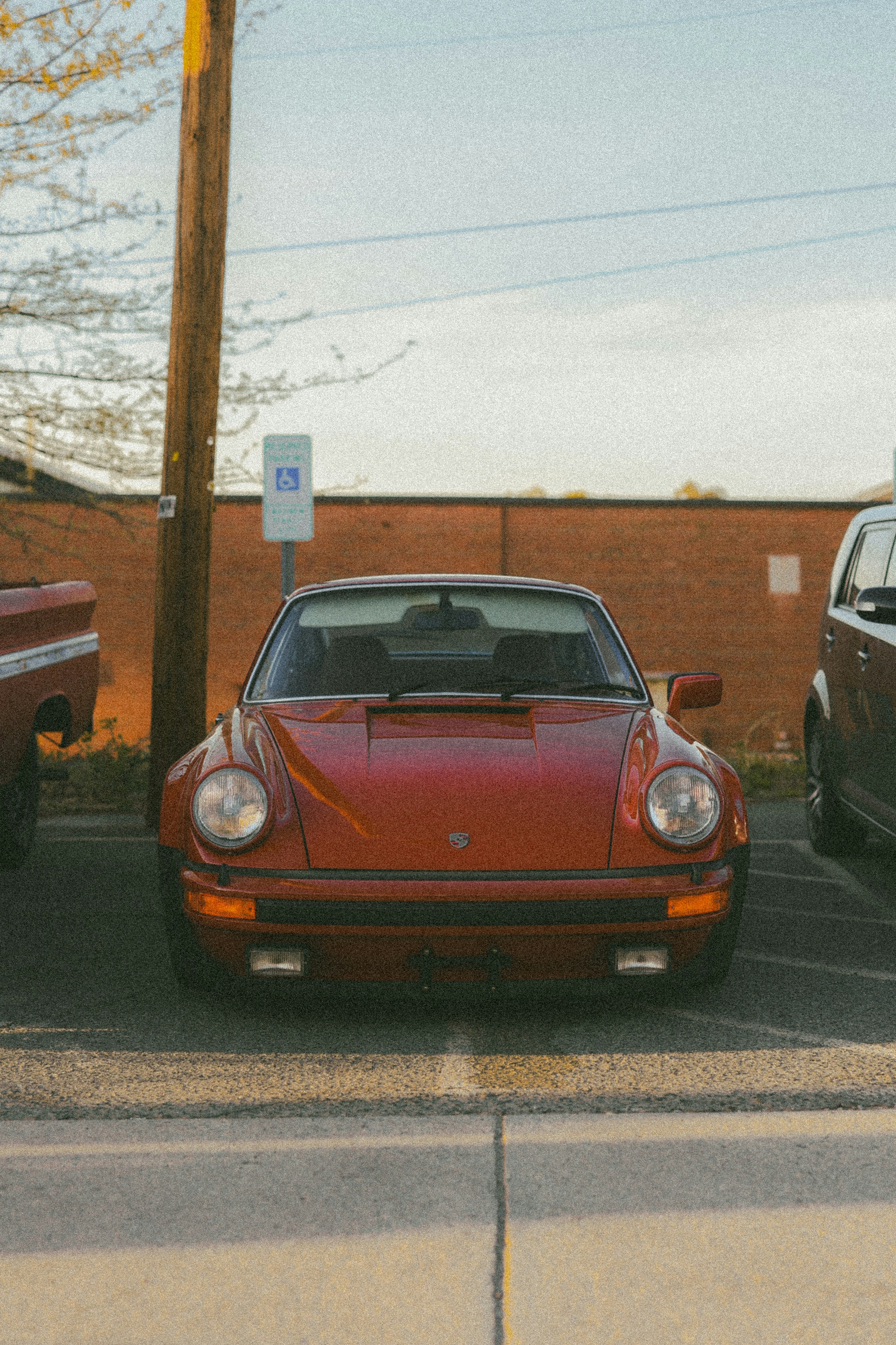 A red porsche parks in a sunny spot.