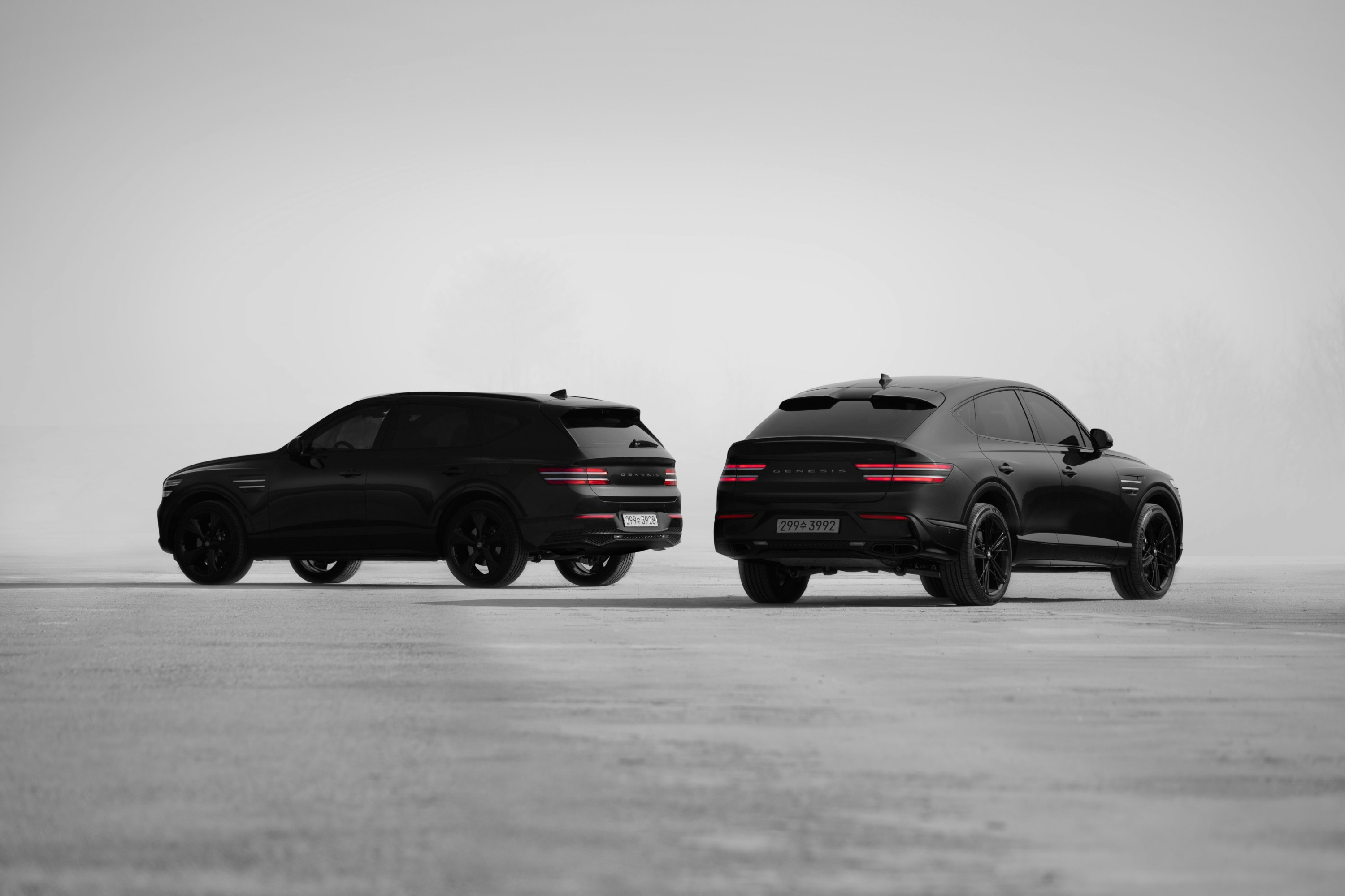 Two black suvs parked next to each other.