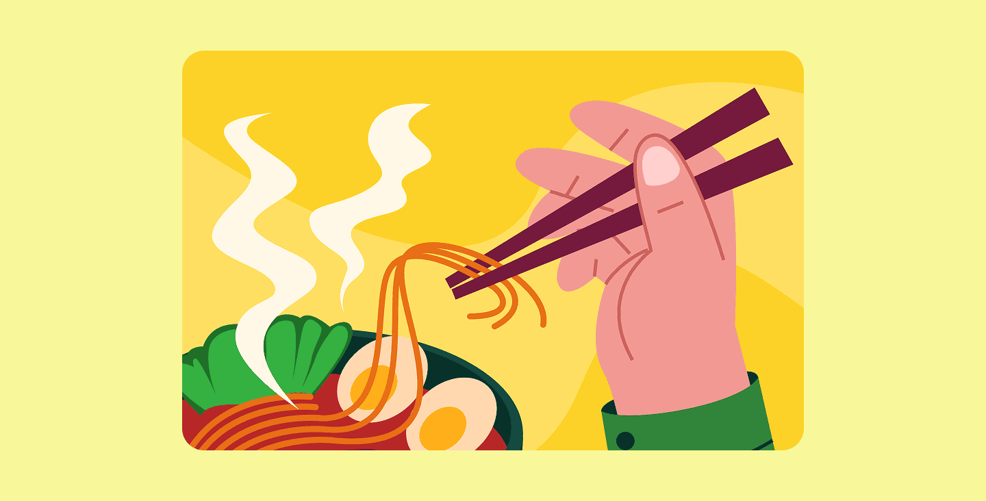 Hand using chopsticks to eat ramen noodles.