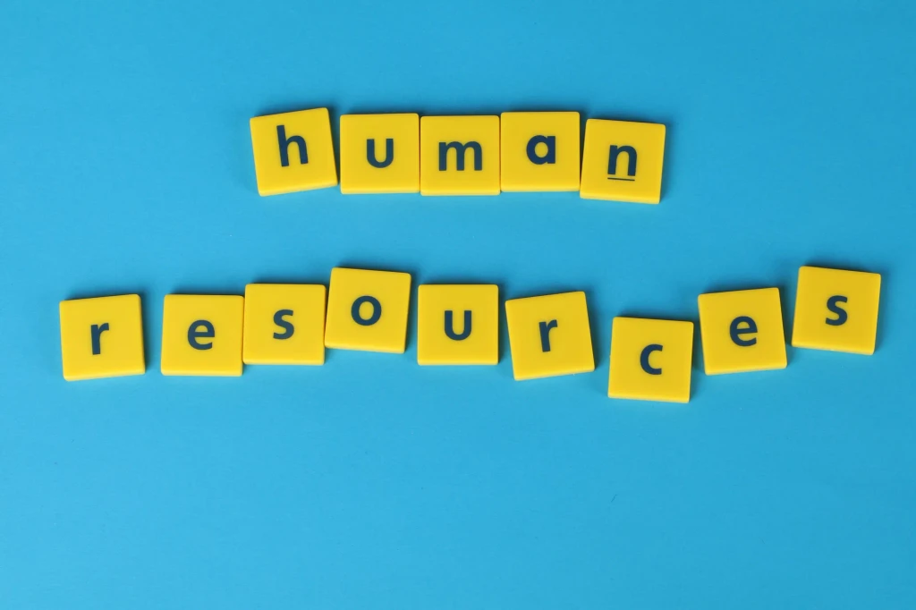 Buchstaben „human resources“ auf blauem Hintergrund, Symbol für Personalwesen