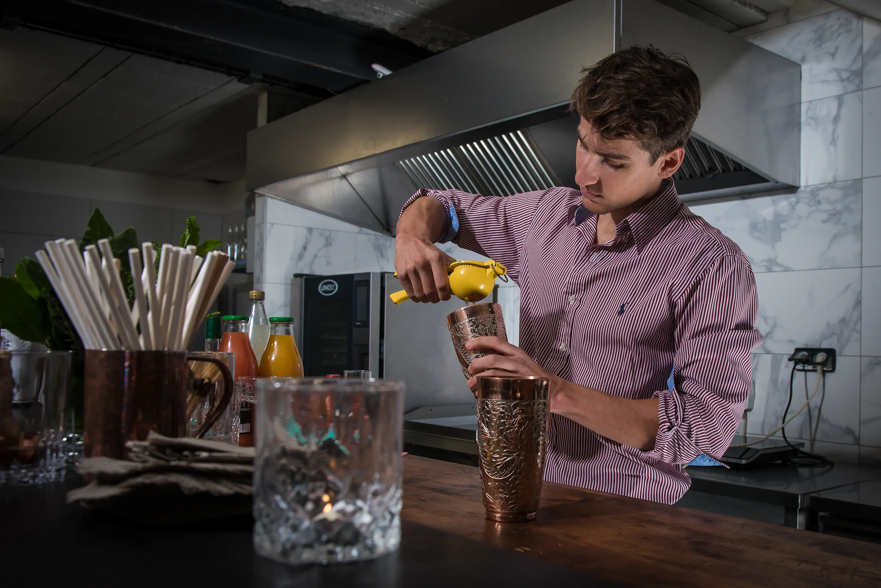 Barman presse un citron dans un shaker
