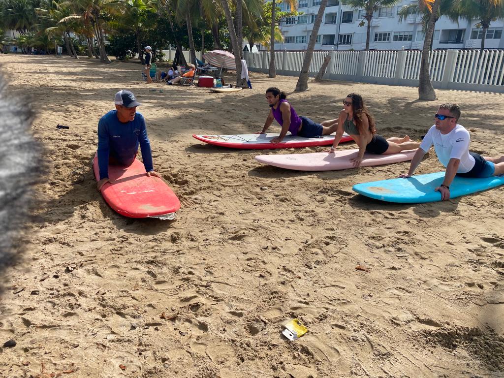 Surf instructor teaching two people on a Puerto Rico beach during documentary filming