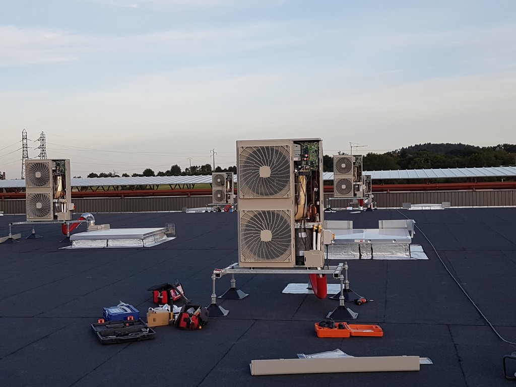 Double pompe à chaleur air-air sur le toit d'une grande surface à Nancy. Des équipements de travail sont posés aux pieds de la pompe à chaleur